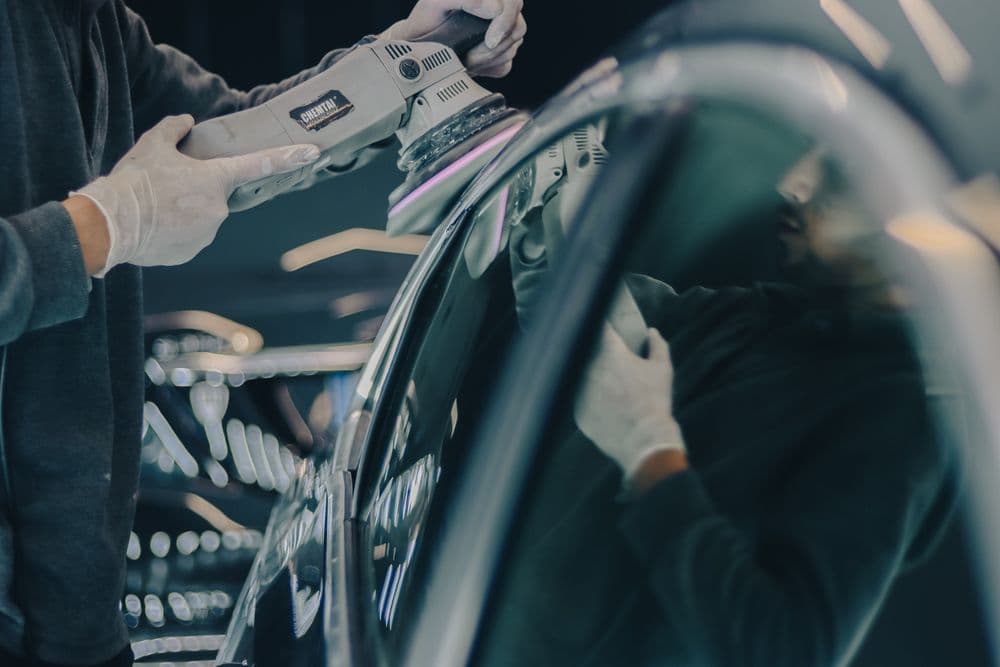 Een polijstmachine wordt gebruikt op de lak van een auto (sfeerbeeld)