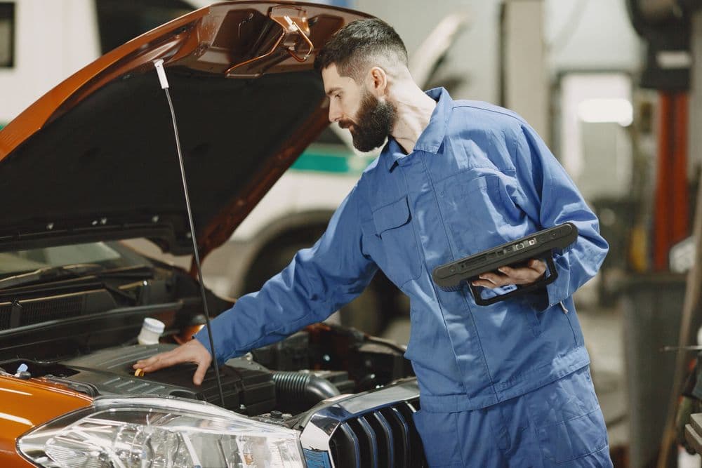 Monteur controleert een motor met diagnoseapparatuur; algemene sfeerfoto, geen medewerker van Lindeboom