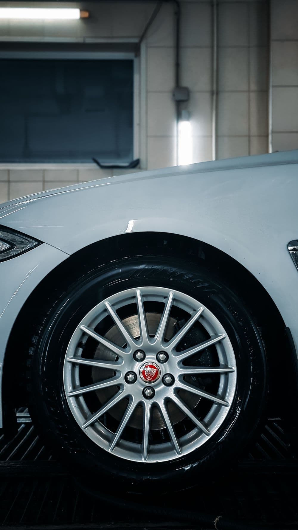 Lichtmetalen velg van een moderne auto in een garage (sfeerbeeld)